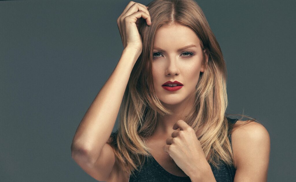 pexels photo 19163508 19163508 Close-up portrait of a blonde woman with red lipstick posing in a studio setting.