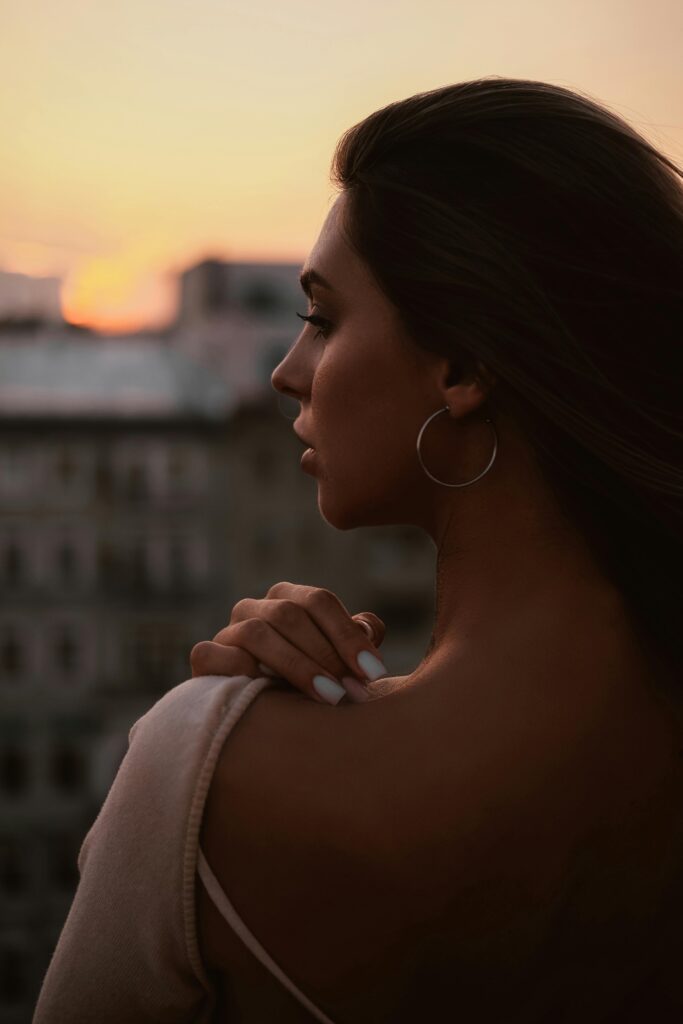 pexels photo 27304892 27304892 Profile of a woman gazing at the sunset from a cityscape view, exuding elegance and calmness.