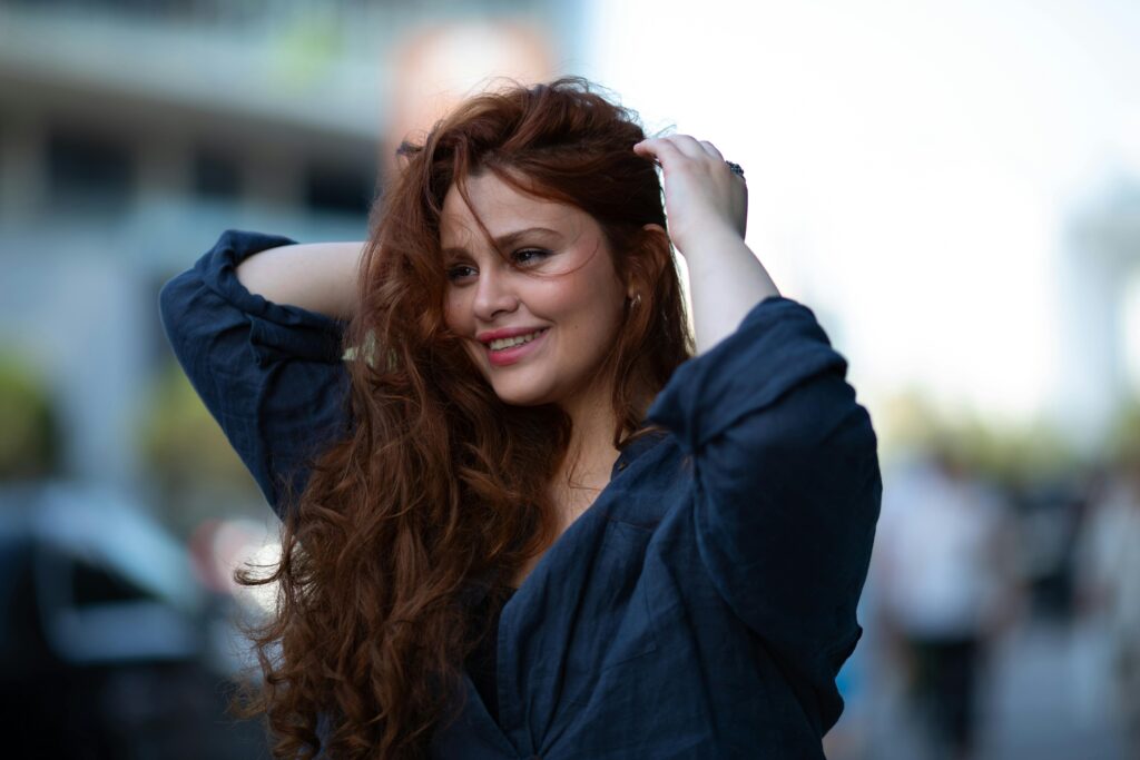 Portrait of a smiling woman with flowing hair on a sunny day in Baku, Azerbaijan.