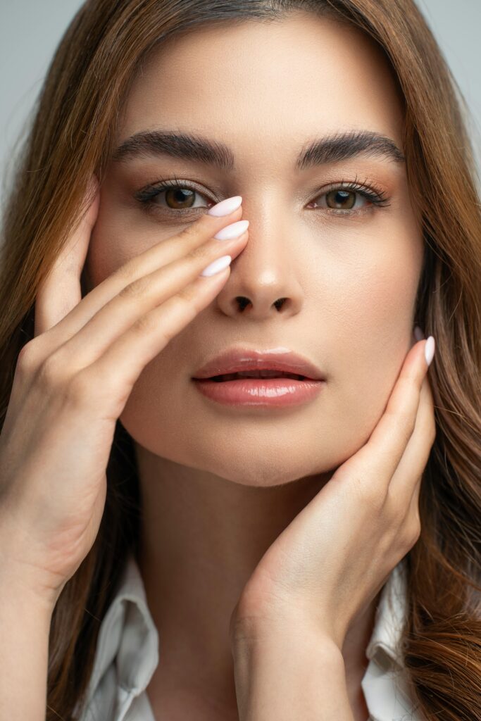 Close-up portrait of a woman with elegant makeup and smooth skin, exuding modern beauty.