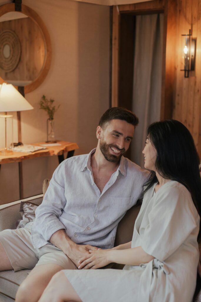 pexels photo 8834633 8834633 A happy couple in casual attire enjoys a moment together on a cozy sofa at home.