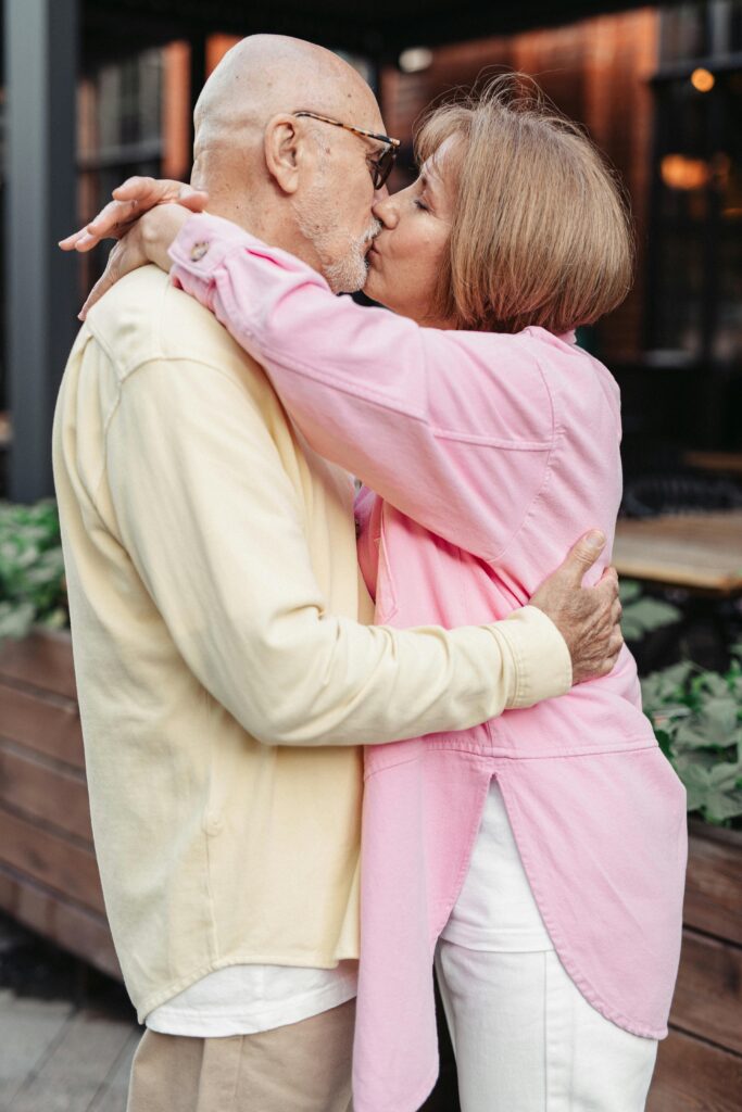 pexels photo 8972290 8972290 A senior couple shares a tender kiss outdoors, showcasing love and togetherness.